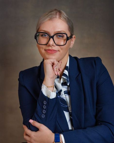 A bald man with a beard is wearing a suit and tie.