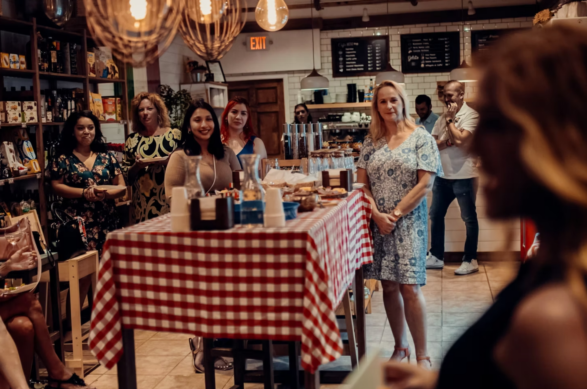 People gathered at a restaurant, listening to a speaker.