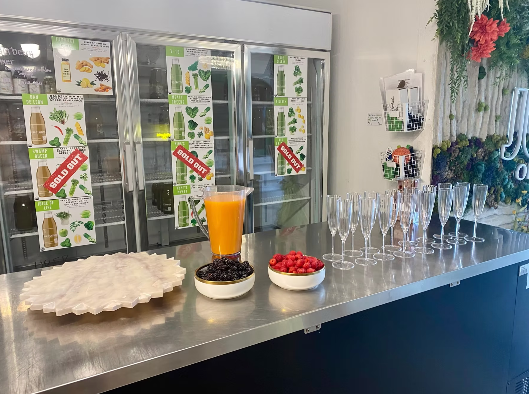 A bar with a drink, berries, and champagne flutes. 