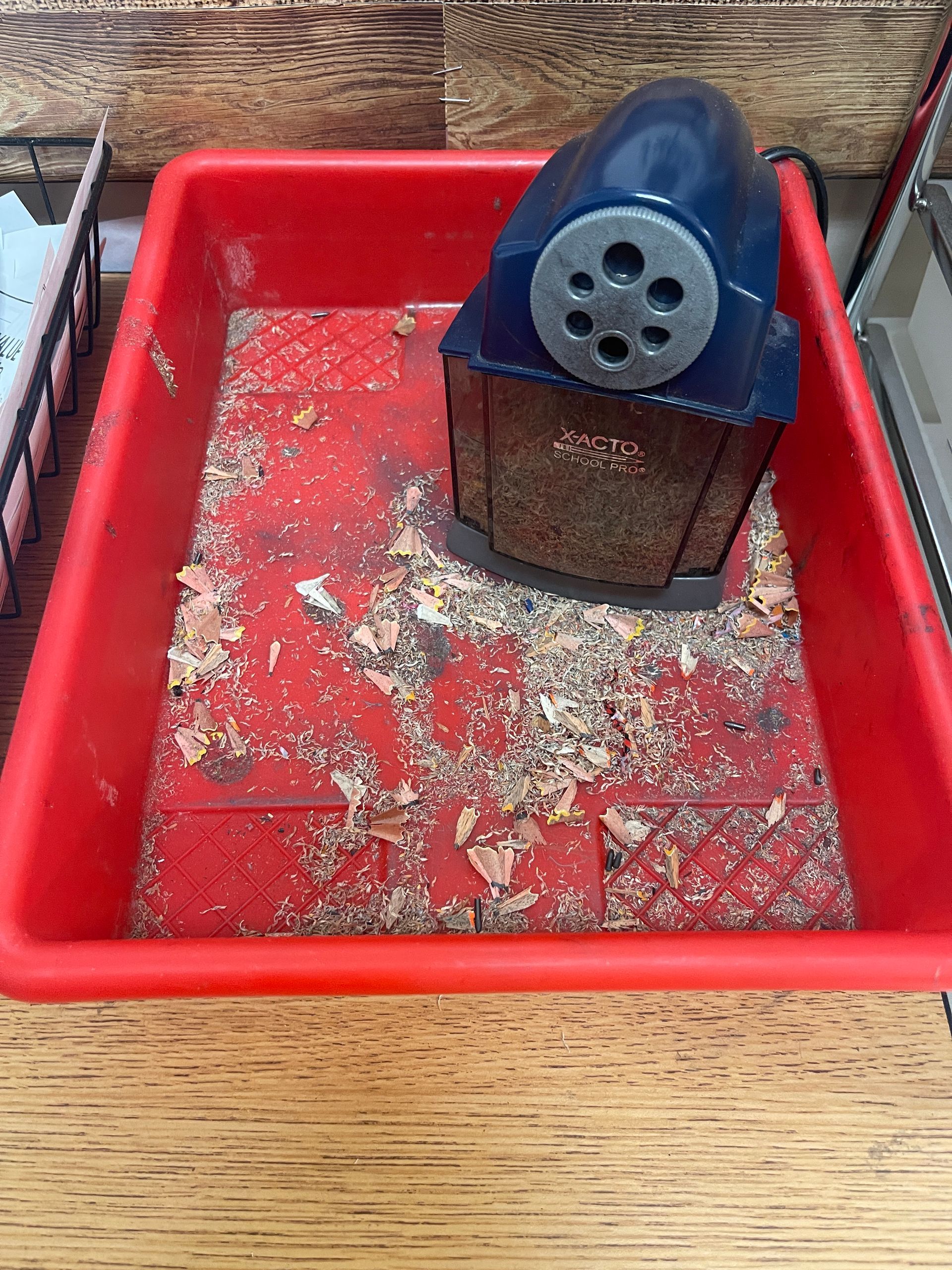 Picture of a pencil sharpener sitting inside a bin.