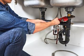 Experienced Plumber — Plumber Repairing the Sink in Columbia, TN