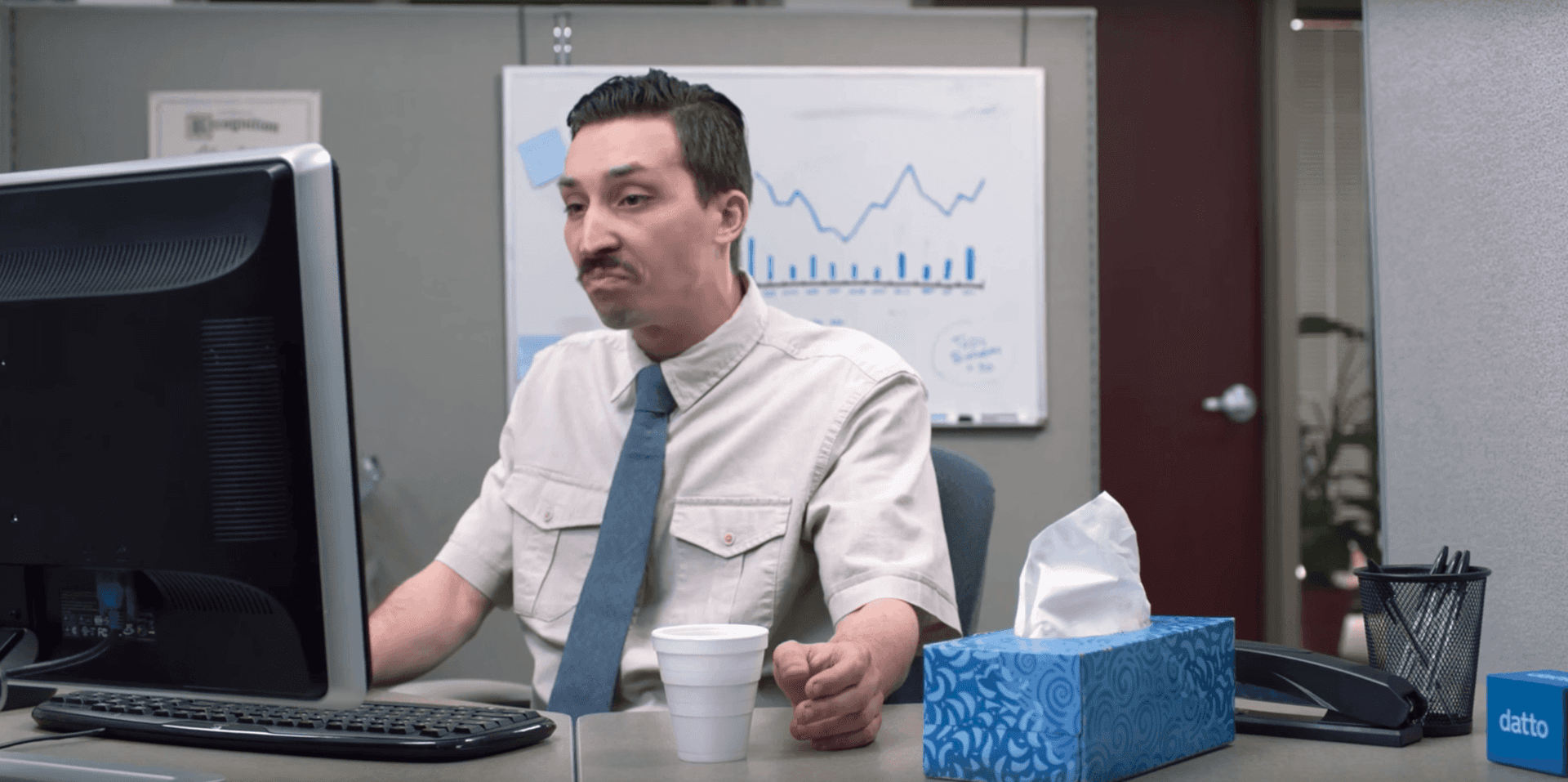 a man is sitting at a desk in front of a computer