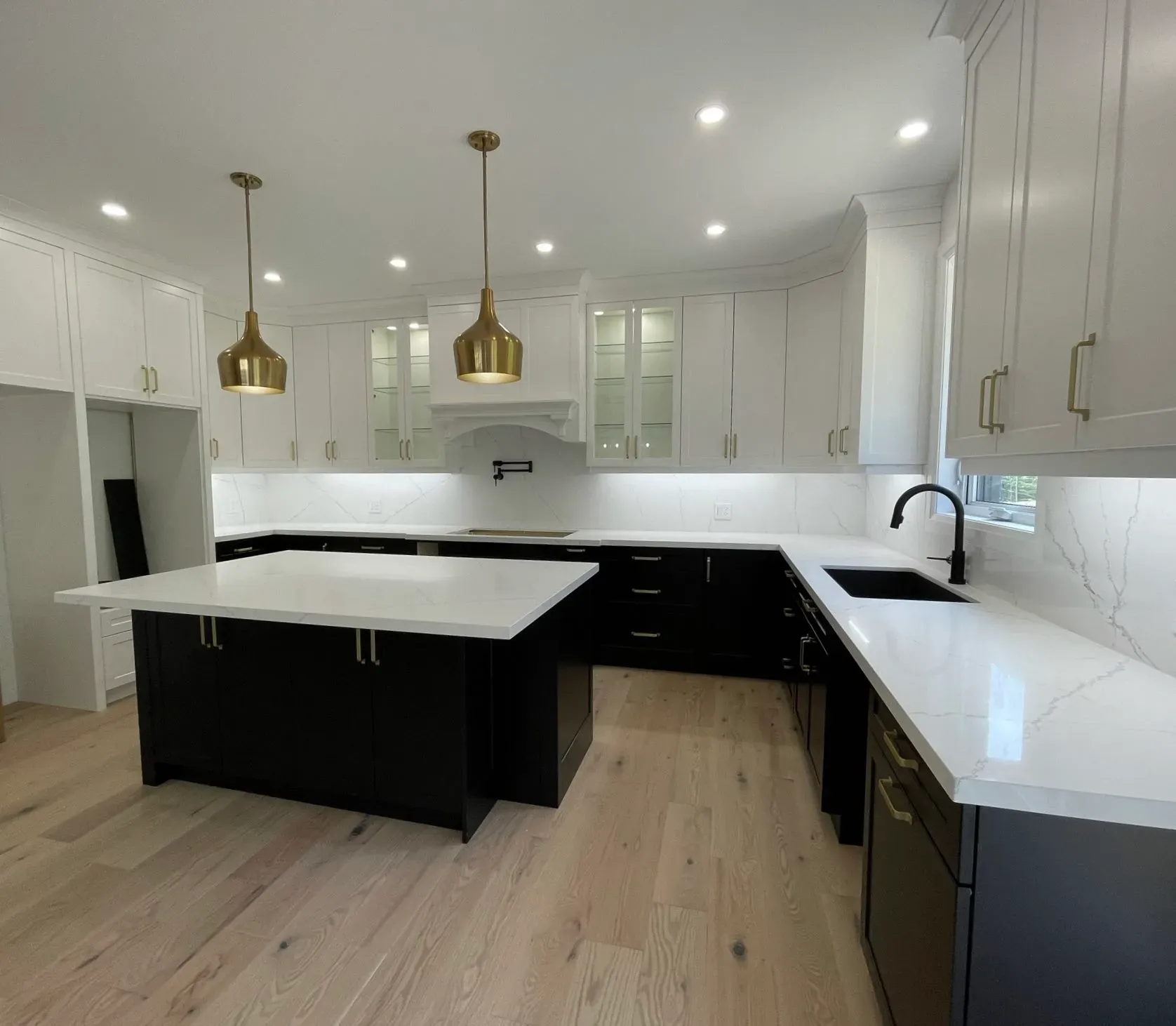 Kitchen quartz counters, black lower cabinets, white upper cabinets.
