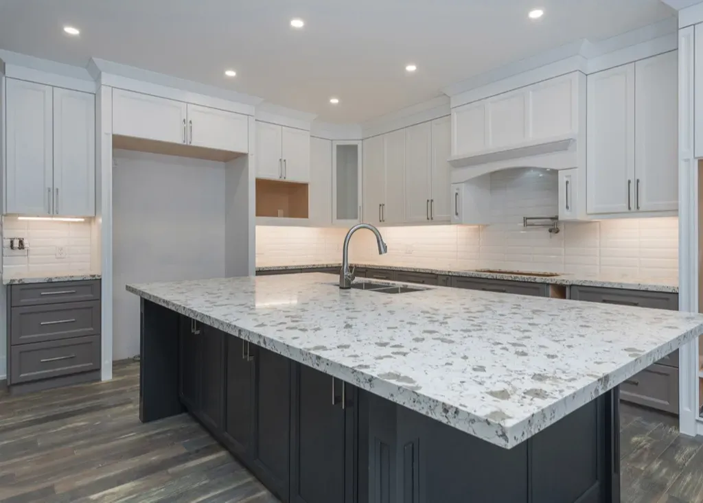 Full kitchen with Quartz counters with white uppers, grey lower cabinets, black island cabinets
