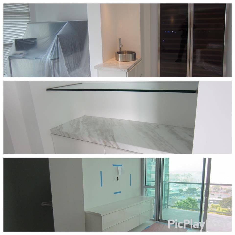 White built-in cabinets and countertops in various areas of a modern apartment, including a sink, a shelf, and a TV console.