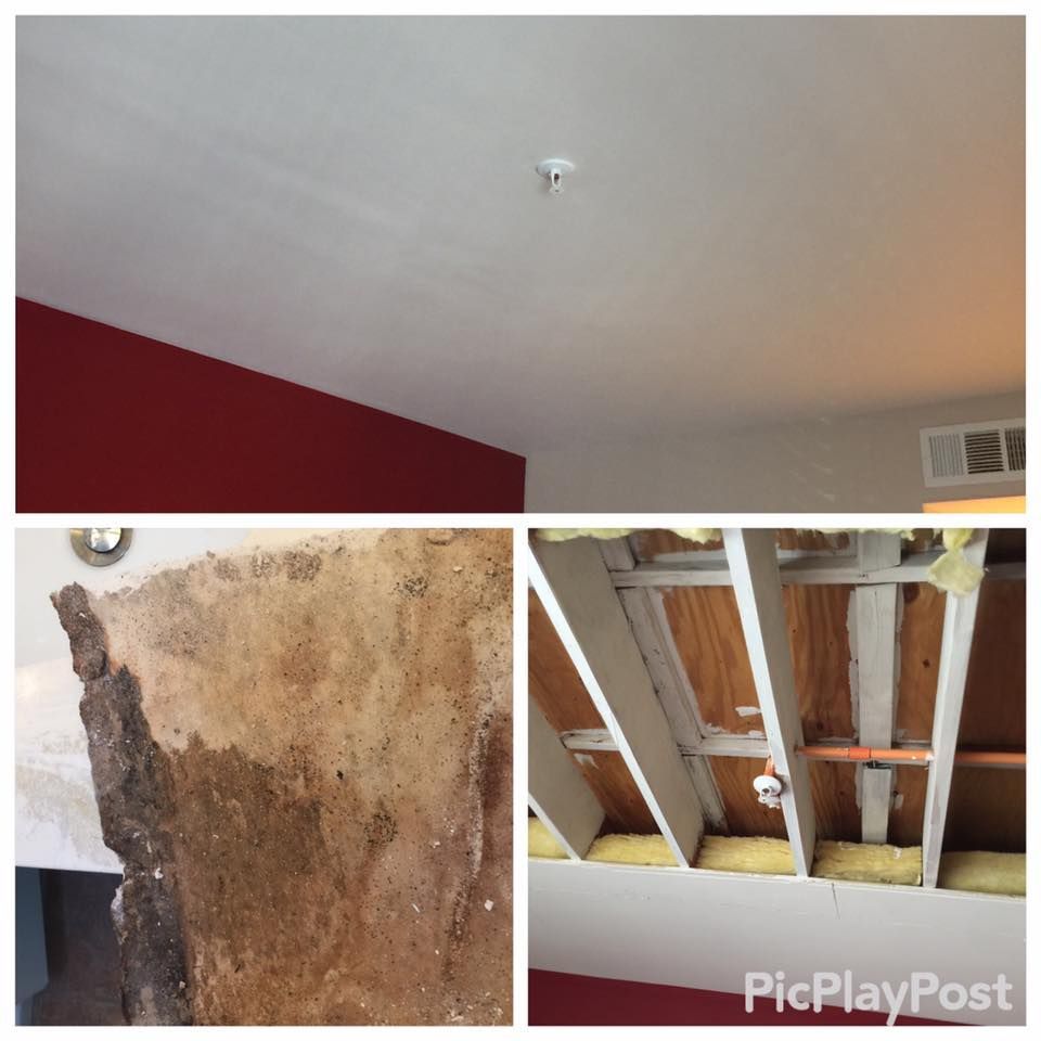 Ceiling with smoke detector, red wall, damaged plaster with water stains, exposed ceiling beams.