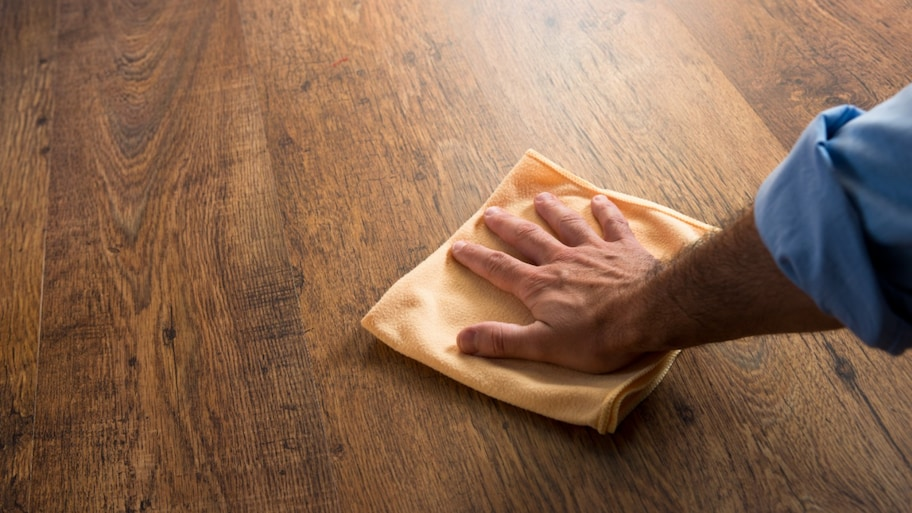 Cleaning and polishing a hardwood floor inside a house in Thornton, CO