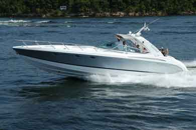 White powerboat speeding across blue water, creating a wake.