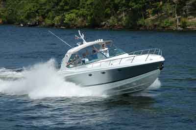 White motorboat speeding across blue water, splashing waves.