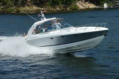 White motorboat speeding on water; passengers visible; sunny day.