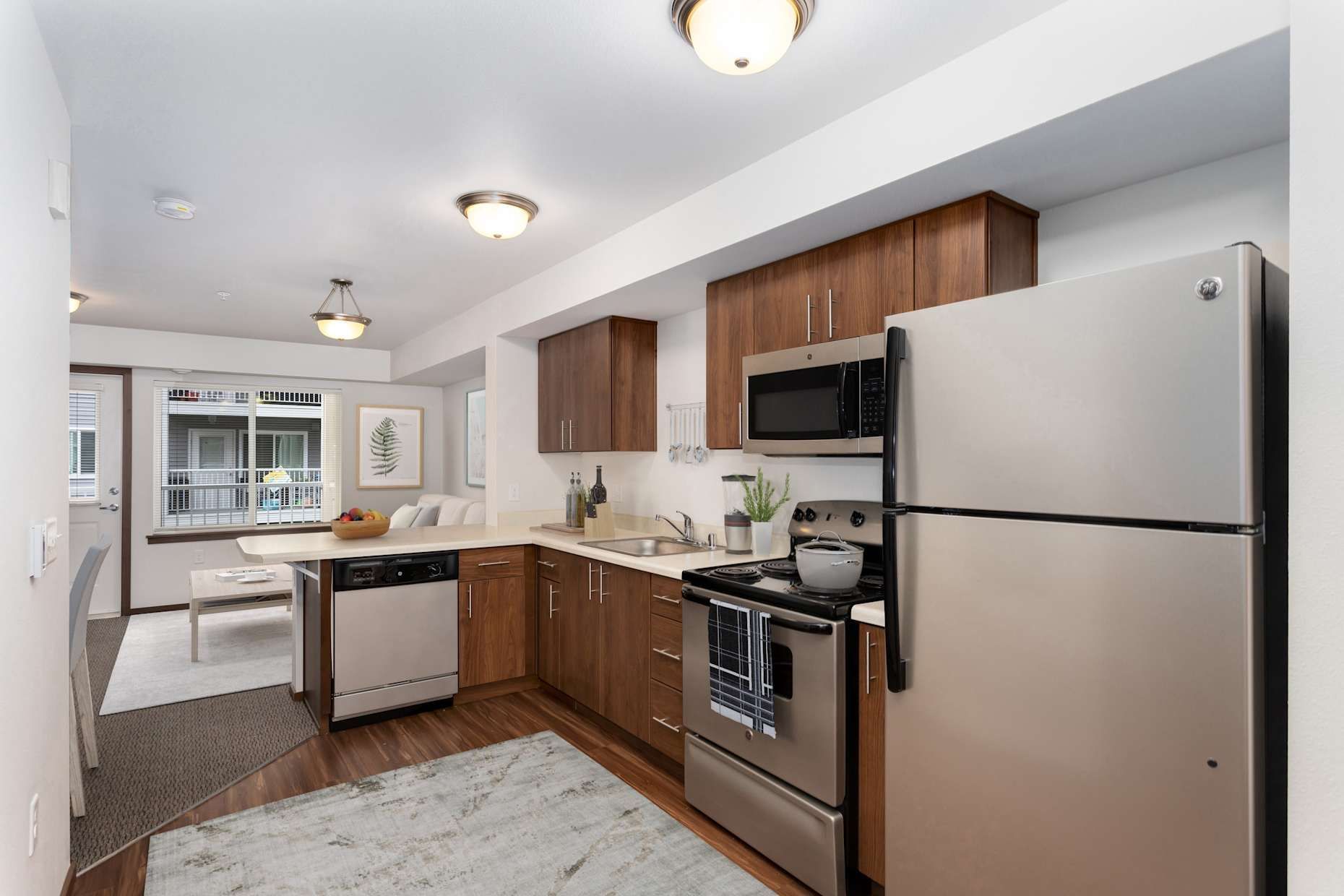 A kitchen with stainless steel appliances and wooden cabinets.