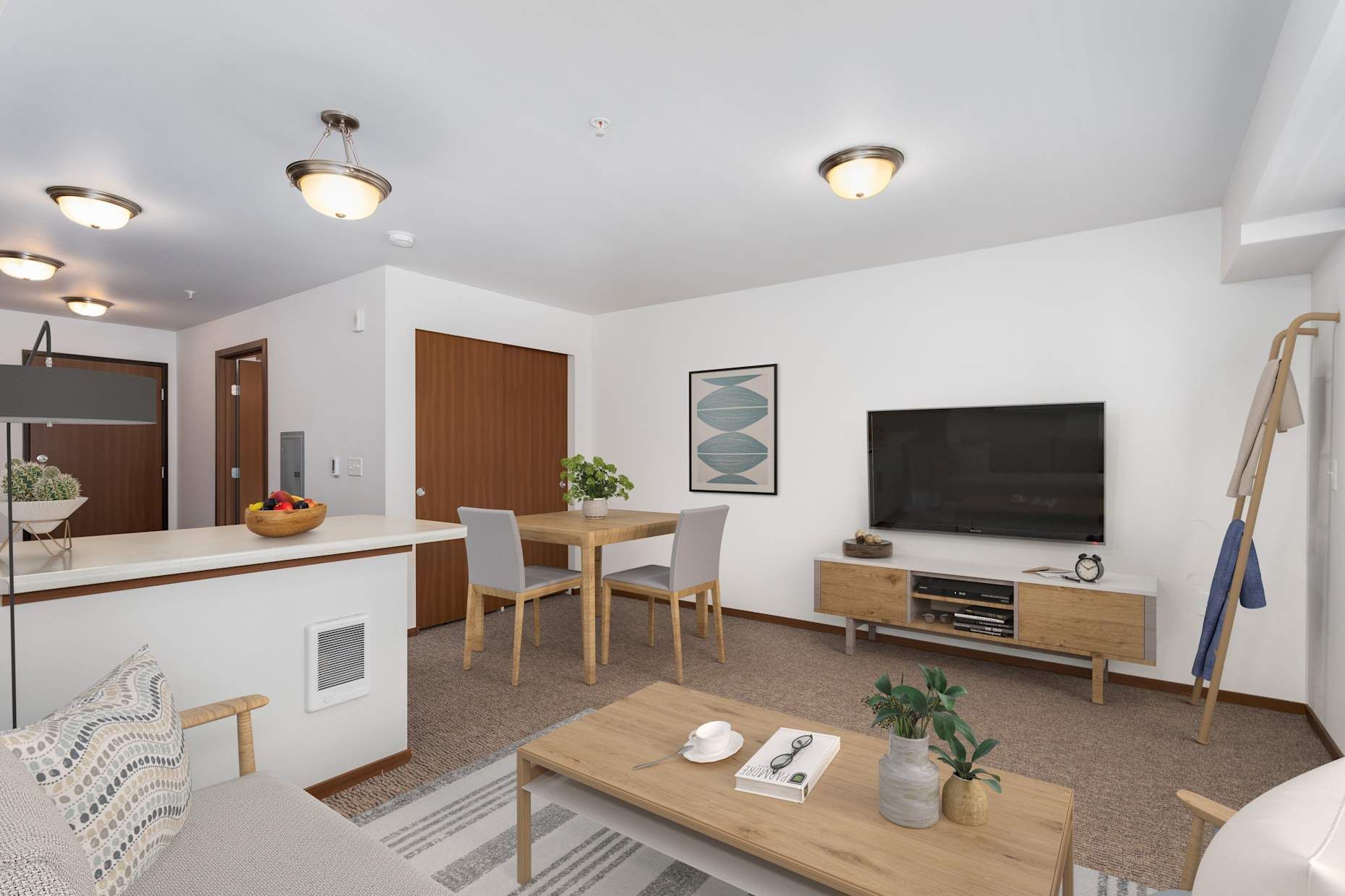 Open-concept living space with a kitchen, dining area, and living room. Neutral colors, wood accents, a TV, and a rug.