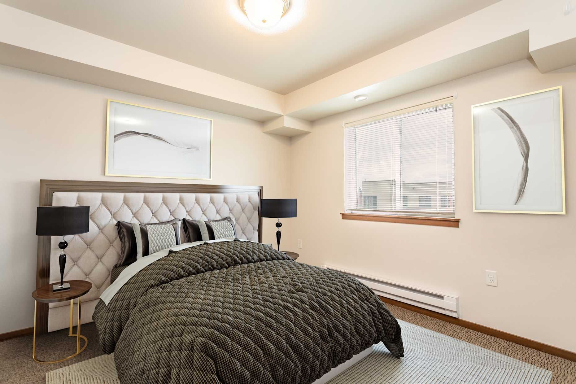 Bedroom with bed, art, lamps, window, and beige walls.
