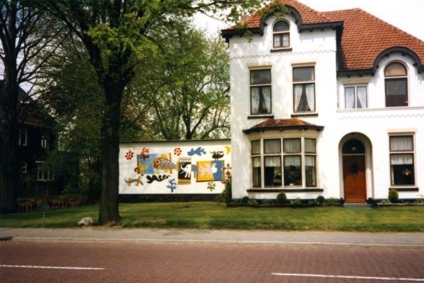 Een groot wit huis met een muurschildering aan de zijkant