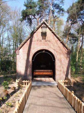 Een bakstenen gebouw met daarin een houten bank