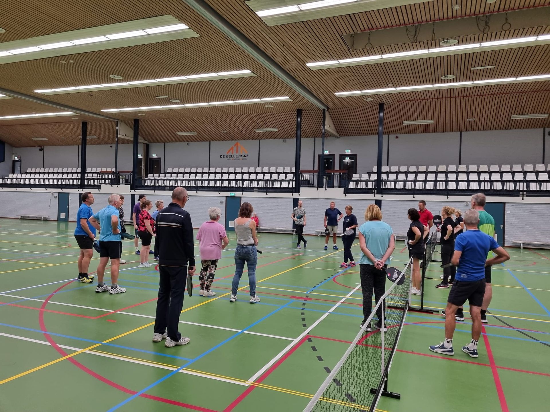 Een groep mensen staat in een gymzaal.