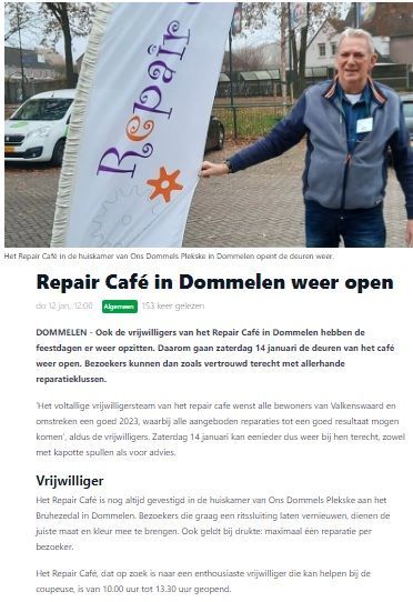 Een man staat voor een banner van een reparatiecafé