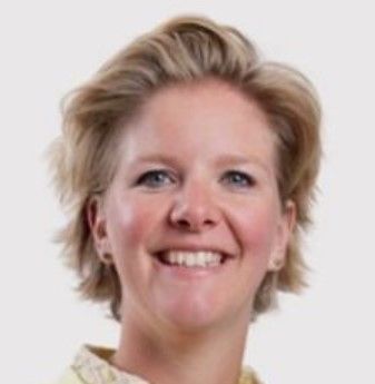 Een vrouw met blond haar lacht op een zwart-witfoto.