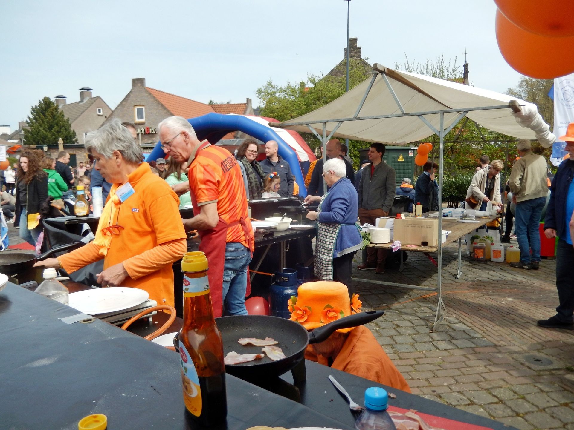 Een groep mensen kookt buiten voor een tent