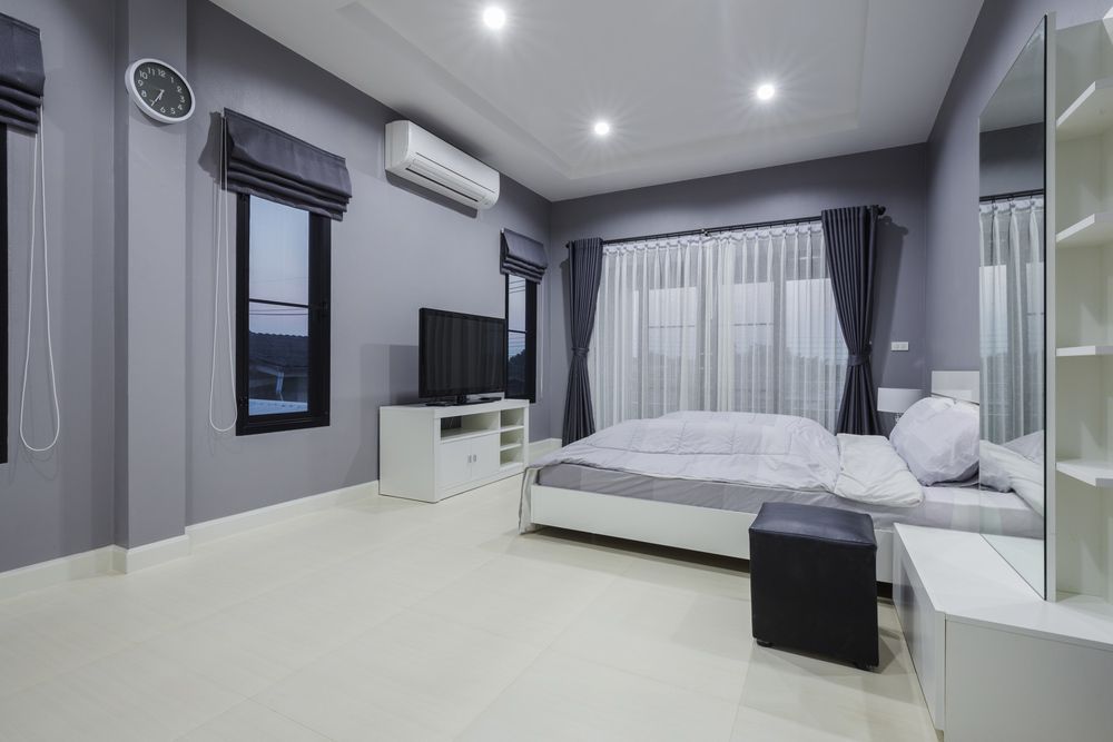 A Bedroom With A Bed , Television , Dresser And Mirror — Morphett Construction In Quirindi, NSW