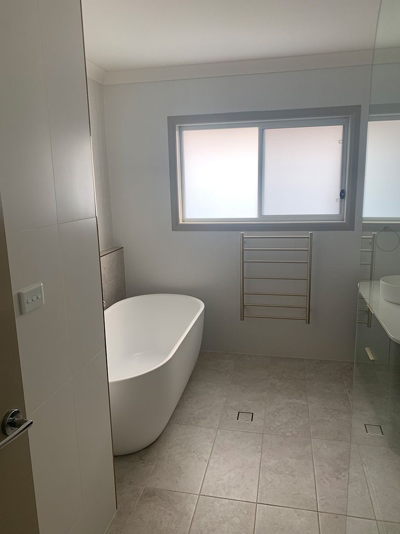 A Bathroom With A Bathtub , Sink , And Window — Morphett Construction In Gunnedah, NSW