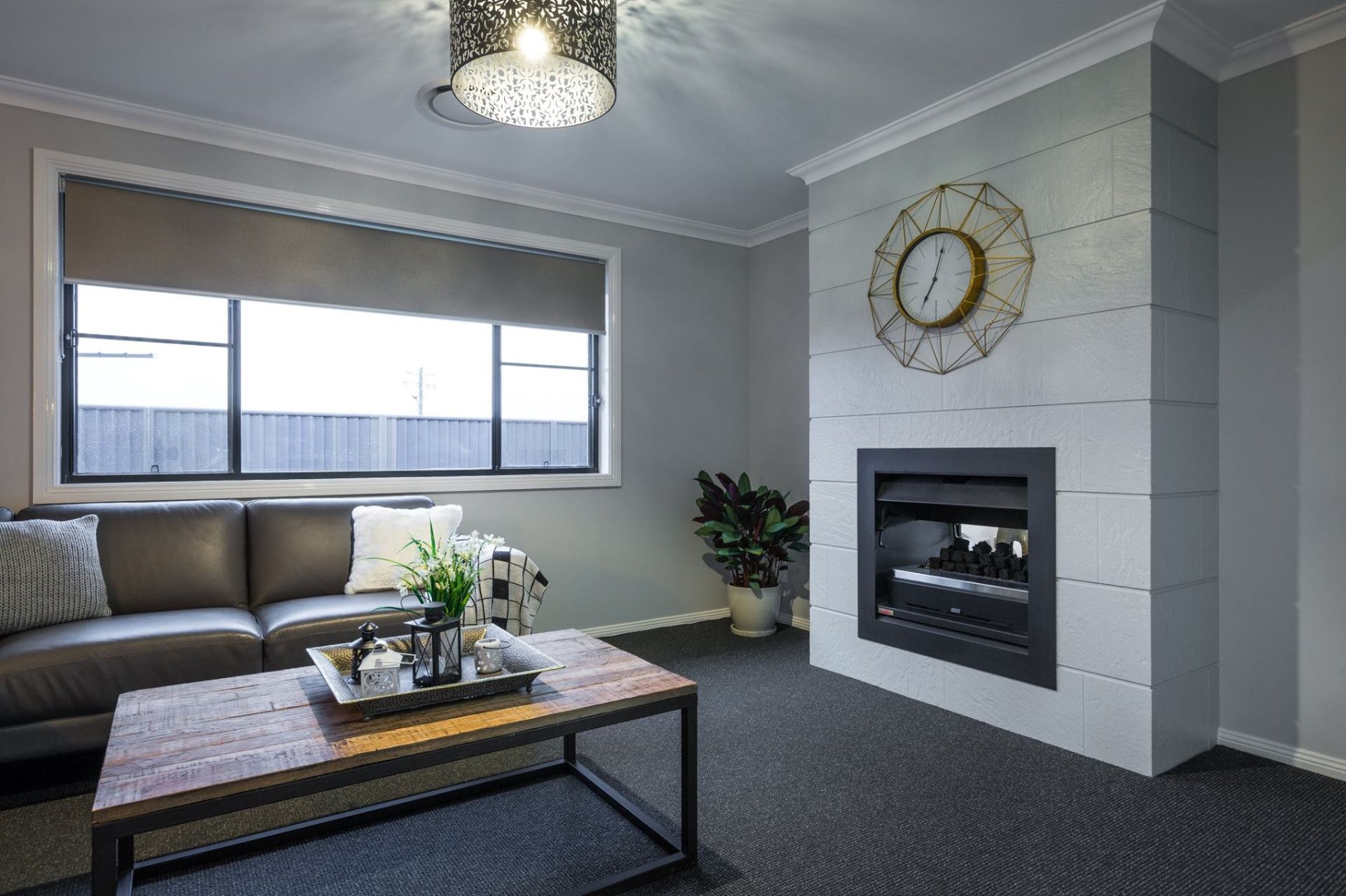 A Living Room With A Nice Coffee Table, Fireplace And Clock — Morphett Construction In Calala, NSW