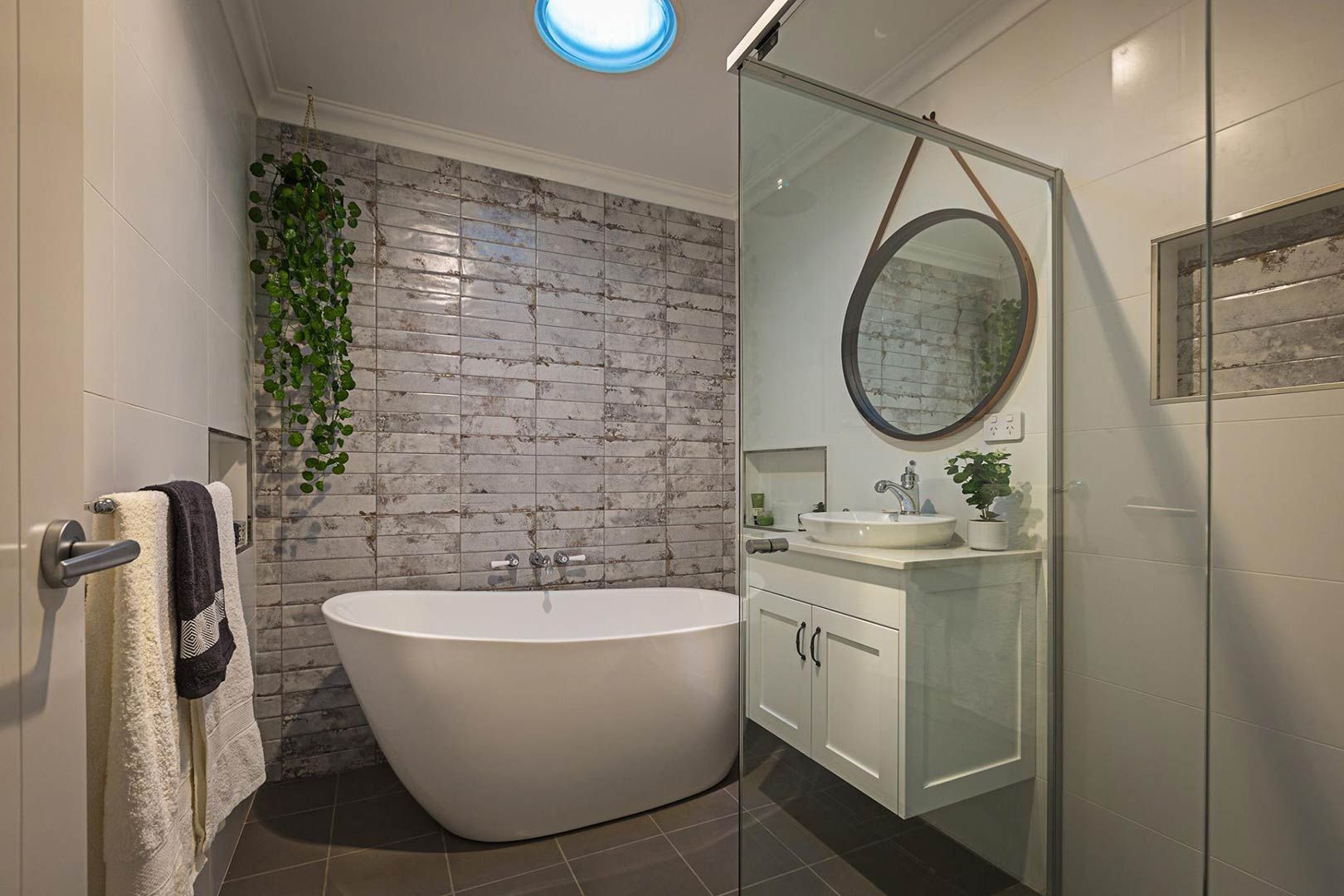 A Bathroom With A Bathtub , Sink , Mirror And Skylight — Morphett Construction In Calala, NSW
