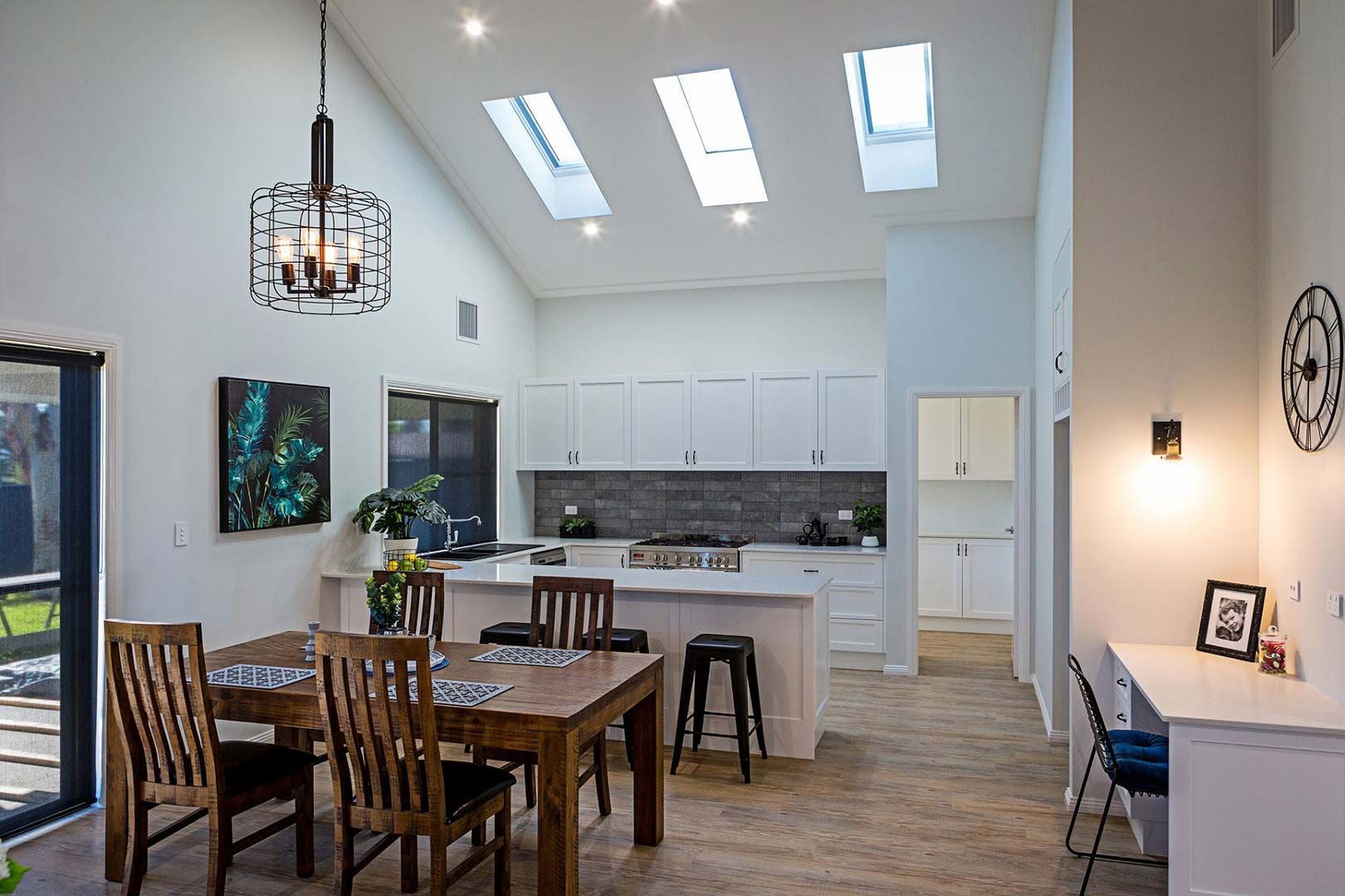 A Dining Room With A Table And Chairs And A Kitchen In The Background — Morphett Construction In Calala, NSW