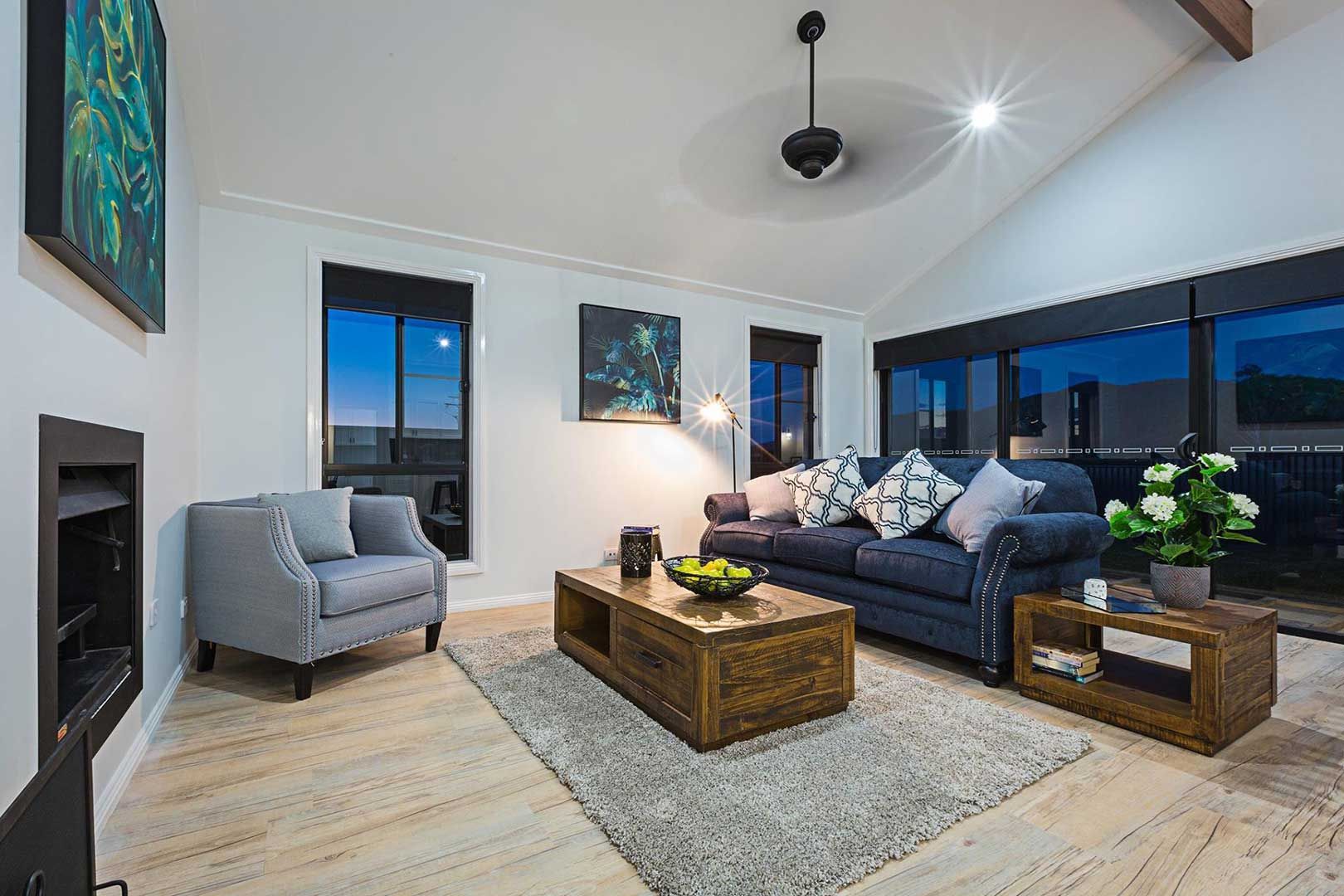A Living Room With A Couch , Chair , Coffee Table And Fireplace — Morphett Construction In Calala, NSW