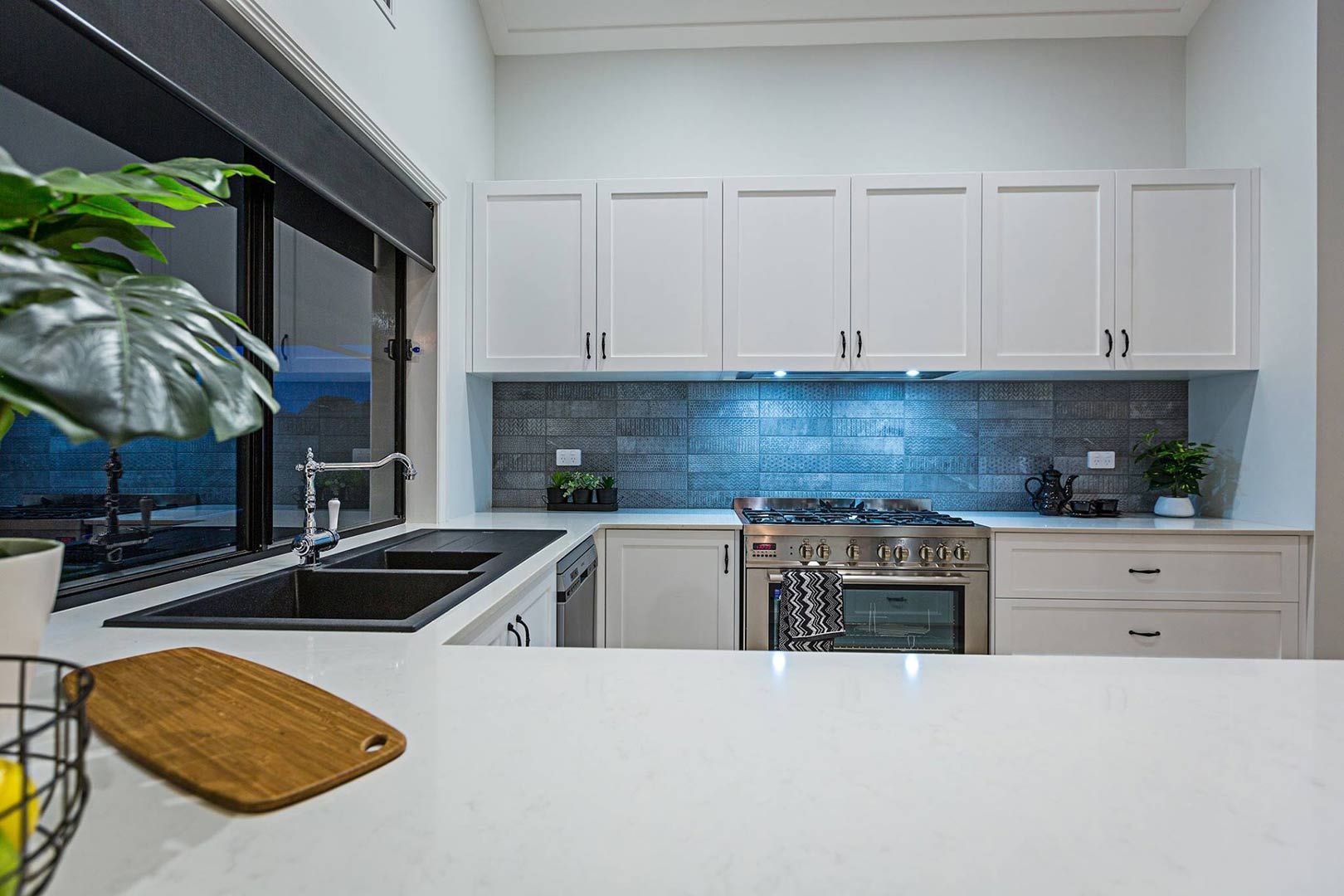 A Kitchen With White Cabinets , A Stove , A Sink , And A Window — Morphett Construction In Gunnedah, NSW
