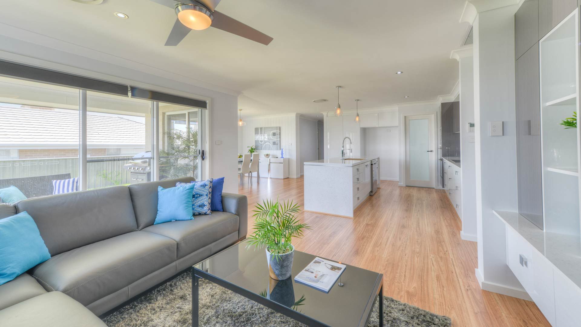 A Living Room With A Couch , Coffee Table , And Ceiling Fan — Morphett Construction In Calala, NSW