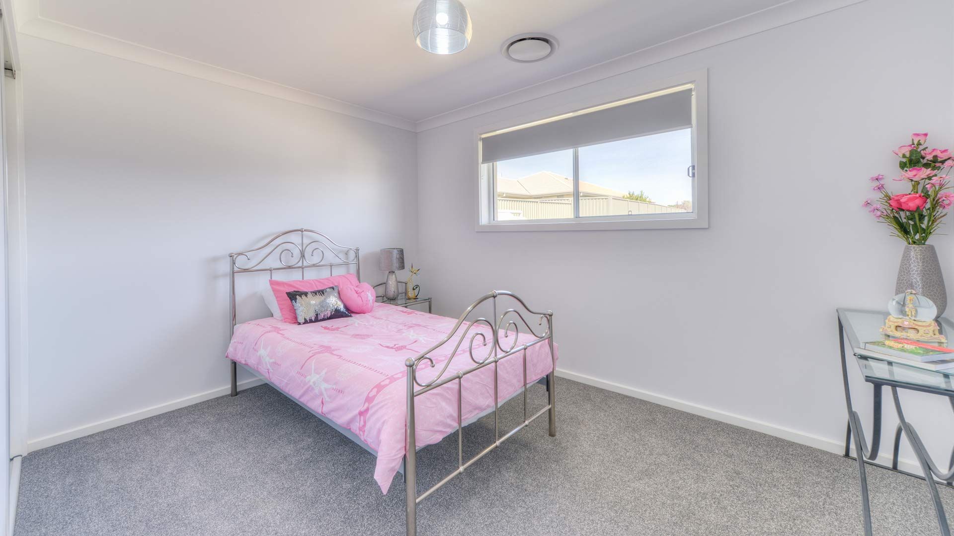 A Bedroom With A Pink Bed And A Window — Morphett Construction In Calala, NSW