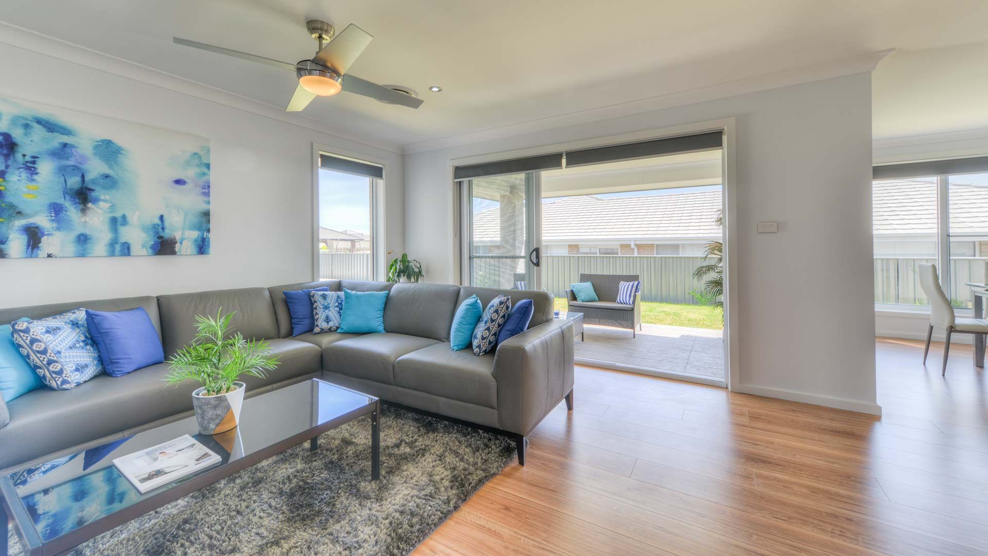 A Living Room With A Couch , Coffee Table , And Ceiling Fan — Morphett Construction In Calala, NSW