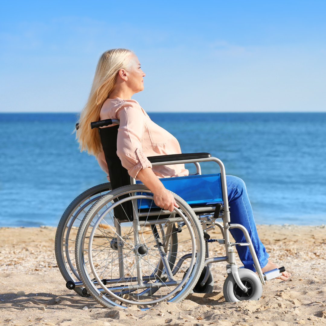 A blond woman in a wheelchair on the beach