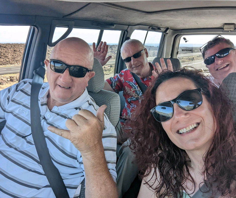 A group of people wearing sunglasses are posing for a picture in a car in sunny Lanzarote.