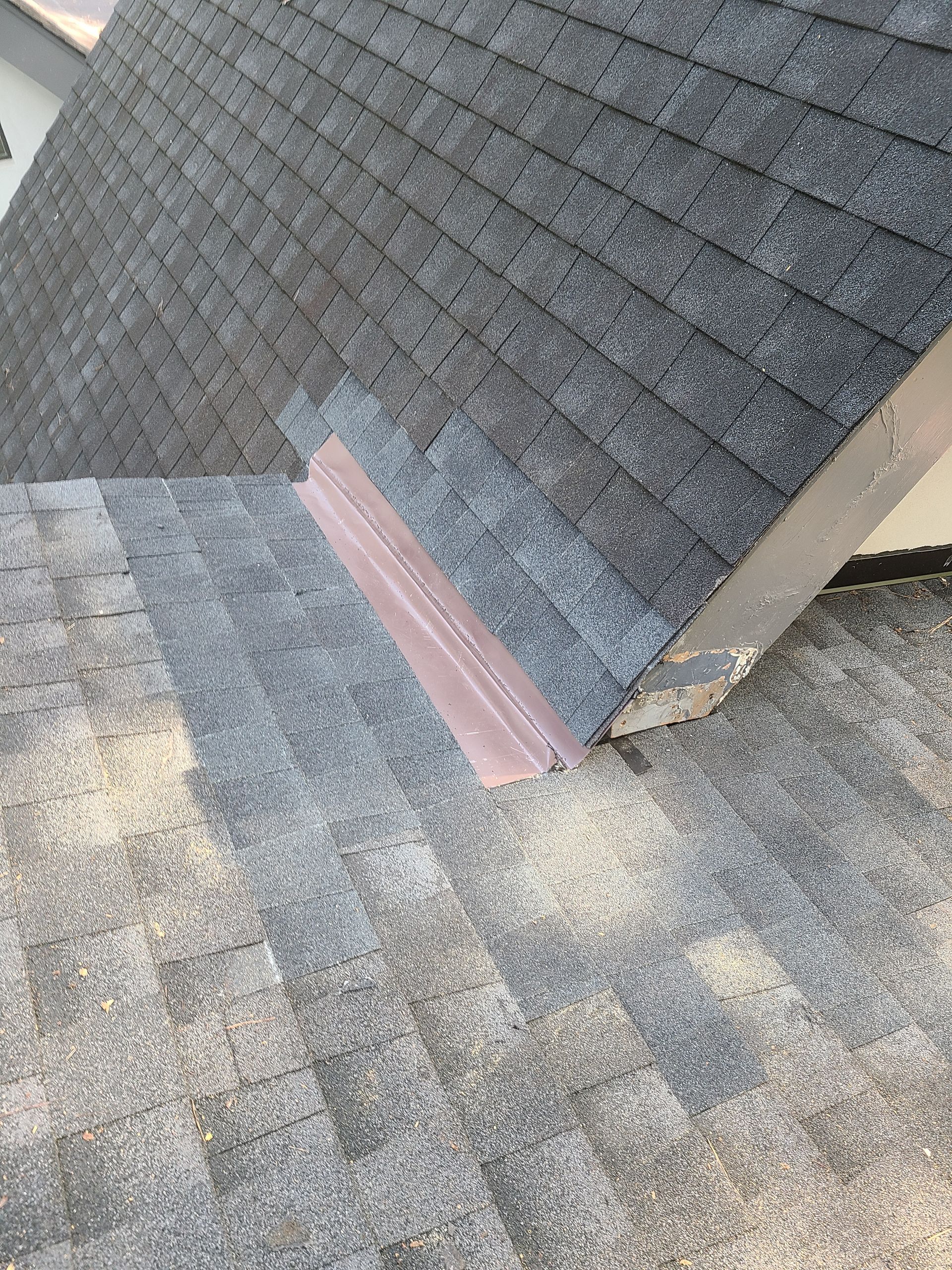 A man is working on the roof of a house under construction.