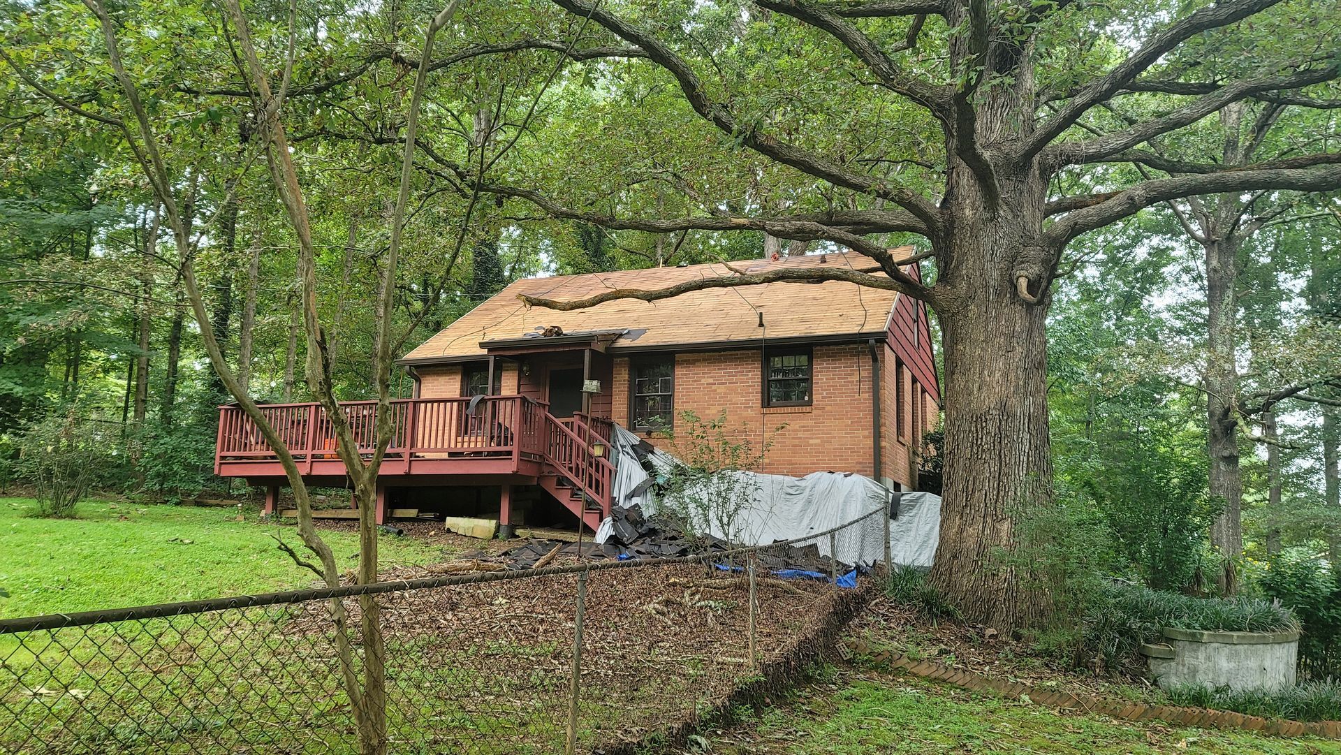 A large brick house with a gray roof and black shutters