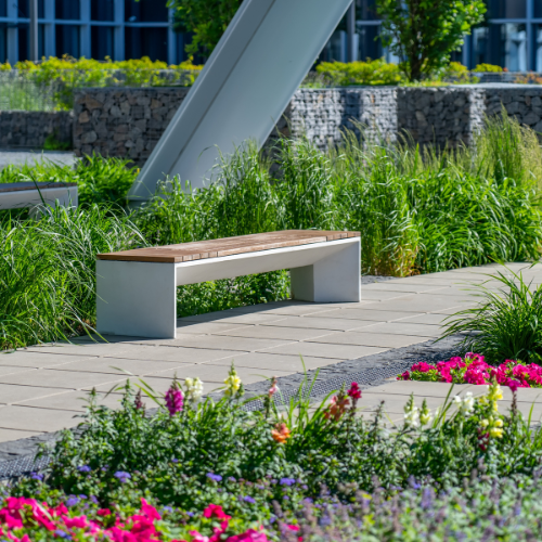 A bench is sitting in the middle of a garden surrounded by flowers.