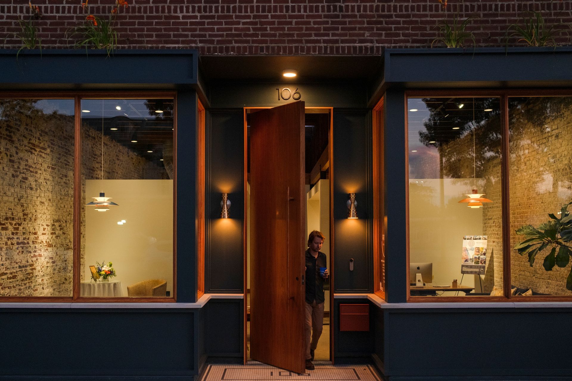 A woman is standing in the doorway of a building.