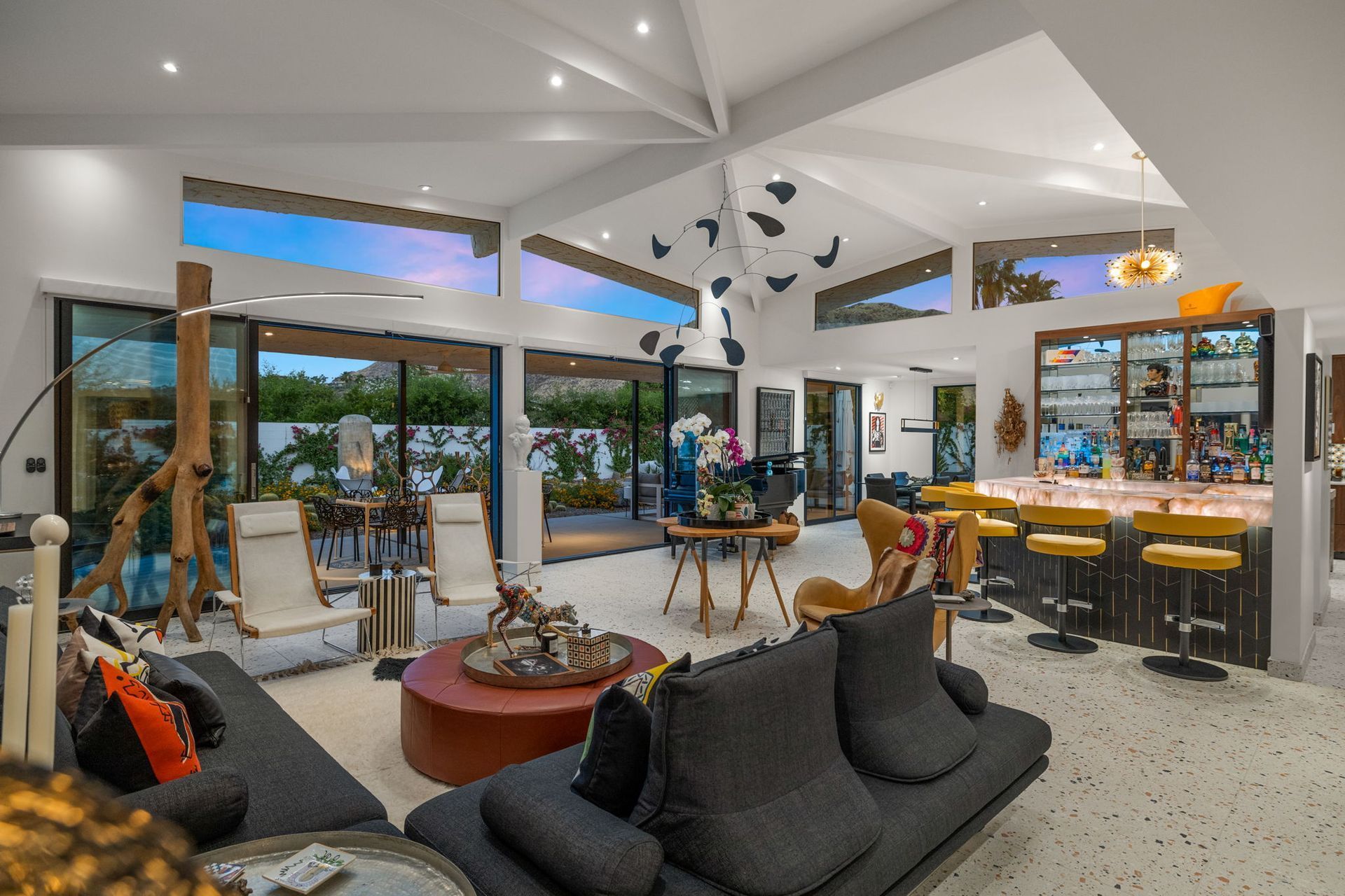 Luxurious living room with open bar, dark sofa, and outdoor access.