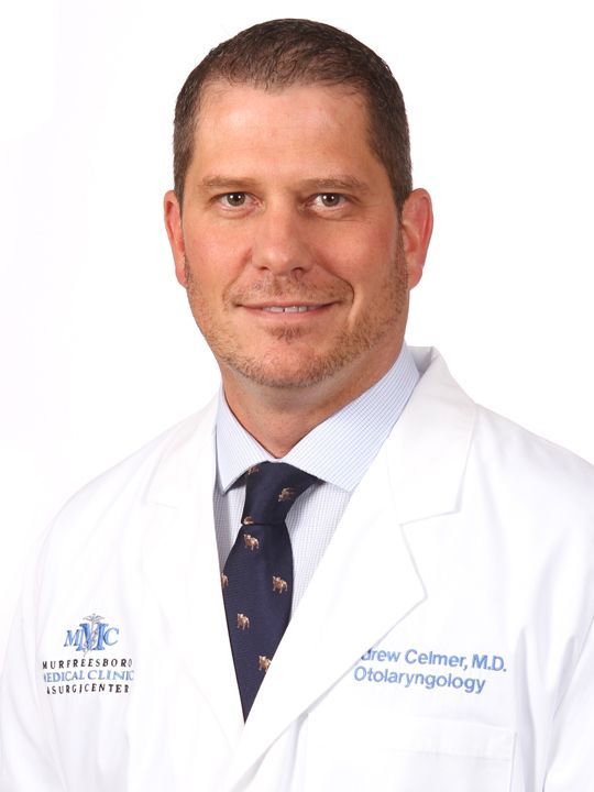 a man in a white coat with the name drew celmer on it