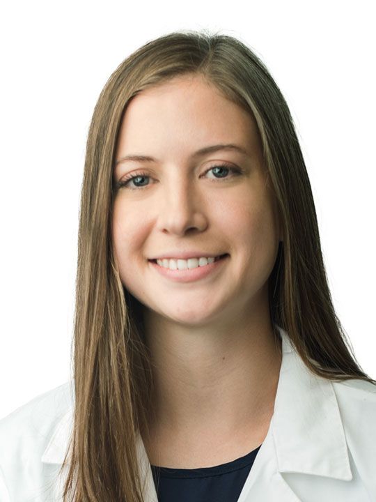 A woman wearing glasses and a white lab coat with the letters npc on it