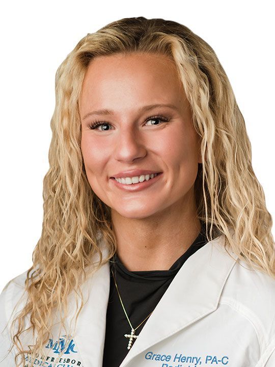 A woman in a white lab coat is smiling for the camera