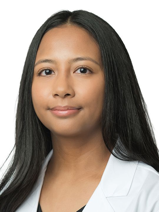 A woman wearing a white coat.
