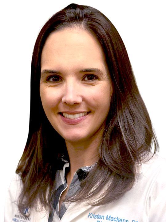 A woman wearing glasses and a white lab coat with the letters npc on it