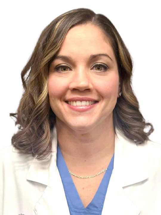 A woman in a white lab coat is smiling for the camera.