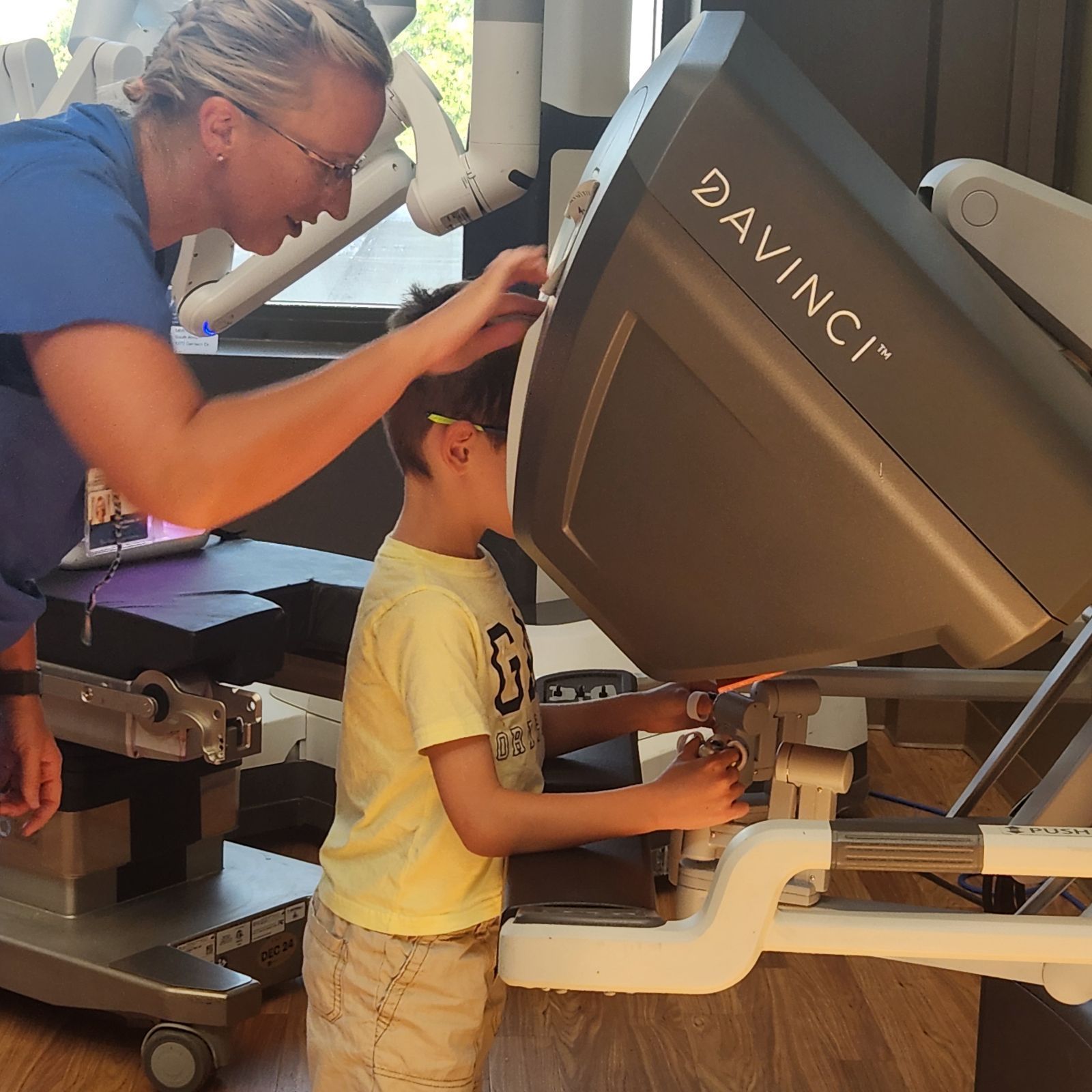 A woman and child are working on a davinci robot