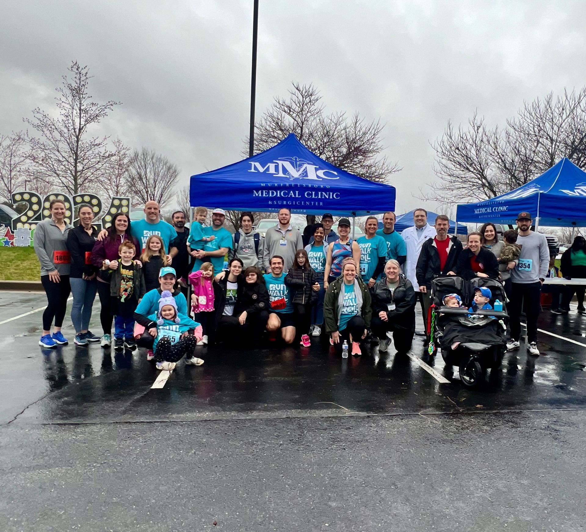 A group of people are posing for a picture in a parking lot.