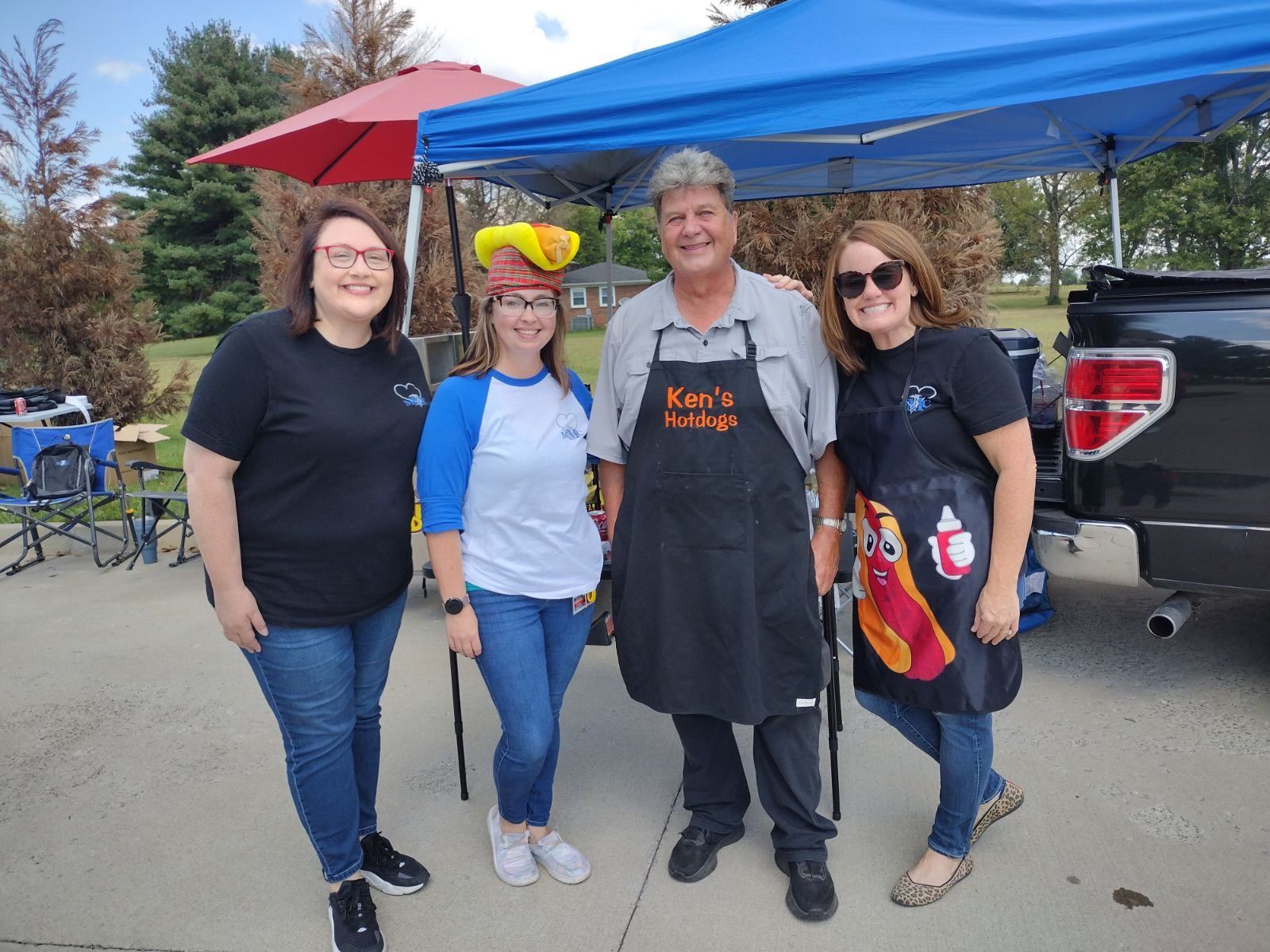 A group of people are posing for a picture in front of a tent.