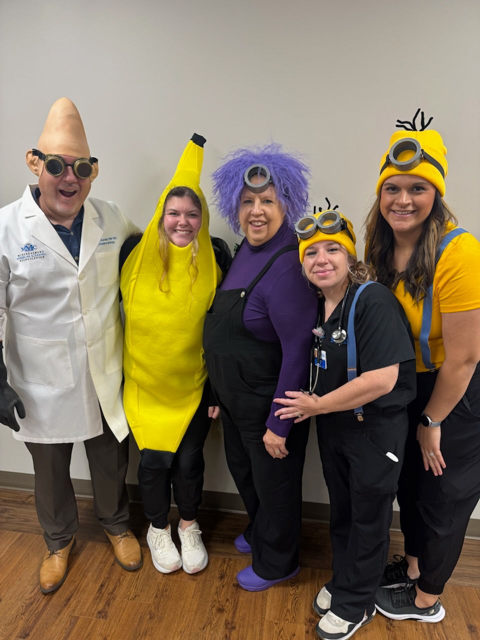 A group of people dressed in minions costumes are posing for a picture.